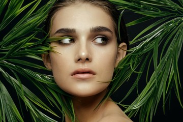 Naklejka premium beautiful woman naked shoulders green leaves spa treatments