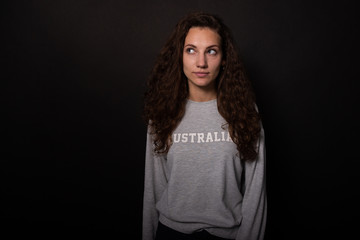 Fototapeta premium Attractive girl interestedly looking up to side. Isolated on black background