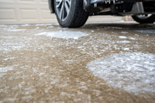 Freezing rain caused buildup of ice on concrete pavement and side runner of vehicle