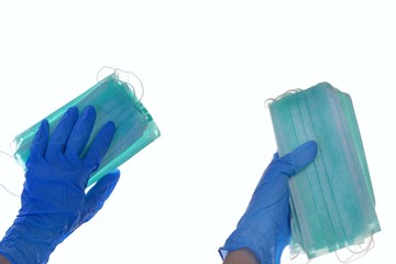 Medical masks and gloves Isolated on a white background. Coronavirus infection epidemic. Cold and flu  protection.A hand in a blue glove holds a pack of medical protective  antivirus masks set.