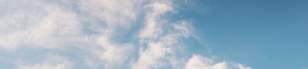 panoramic mode of blue sky with white puffy cotton clouds texture shapes