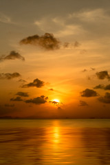 Sunset sky with dark clouds above the lake in golden time.