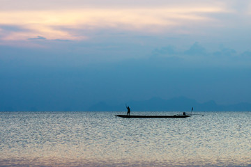 Minimal silhouette fishermans on the lake with twilight sky.