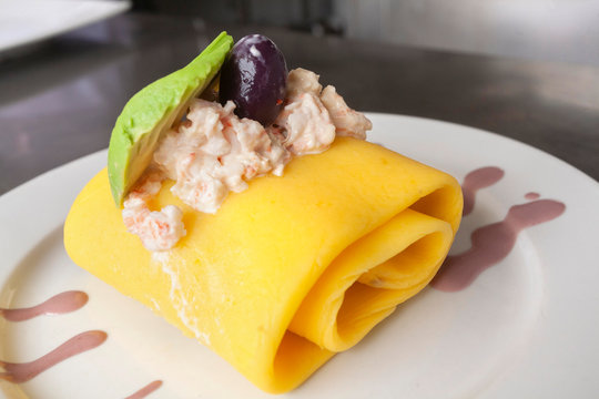 Peruvian food: causa rellena or peruvian layered potato dish filled with crab and decorated with avocado slices and botija olive