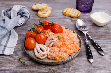 Red rice with seafood tentacles and tomatoes