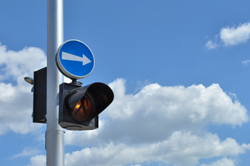 Pedestrian warning light on a pole with an arrow pointing right