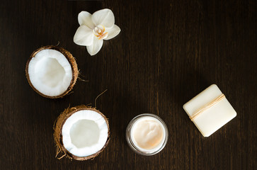 top view on eco natural coconut butter, oil, cream, organic massage cosmetics for preparing for home spa on wooden background, copy space. beauty concept.