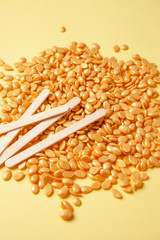 Depilatory wax of Golden color, depilatory spatulas, hot wax type, for face and body, Golden granules on a yellow background