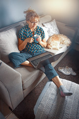 Mujer joven haciendo tele trabajo desde el living de su casa
