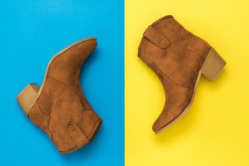 Womens suede boots with striped heels on a yellow and blue background.