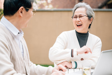 Obraz premium Asian aged couple using a laptop
