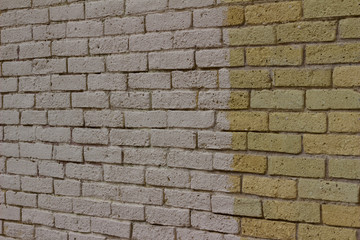 Shabby chic old yellow brick wall texture background with white paint and a natural weathered appearance from aging