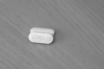 Hydroxychloroquine tablet medication for treatment Malaria, and potential new drug cure for COVID 19 Corona virus closeup. Therapy for Coronavirus. Pharmaceuticals on wooden table.