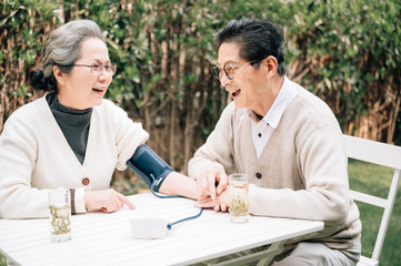 Asian aged couple measuring blood pressure