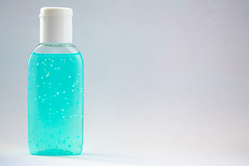 A bottle of hand sanitizer gel. Hand hygiene as coronavirus protection. Antivirus and antibacterial product. Blue liquid with white round granules. Copy space for text