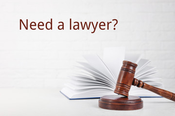 Judge gavel, book and text NEED A LAWYER? on white background
