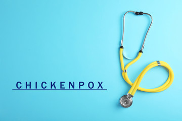 Stethoscope on light blue background, top view. Chickenpox disease