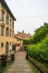 Bergamo, Lombardy region in northern Italy. Deserted street with residential buildings in the upper city on a rainy morning.