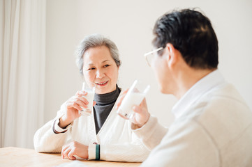 Asian aged couple drinking milk at home