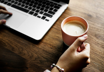A cup of nice hot milk next to a computer laptop