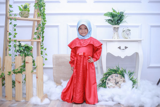 A small female child wearing female Muslim clothing