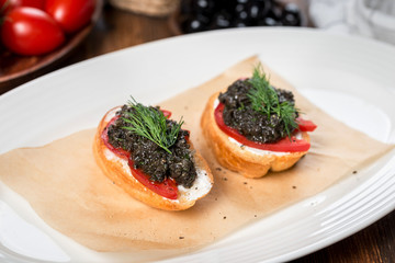 Bruschetta with olive paste on a white plate