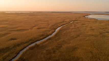 Small wild creek out of city from drone on sunset