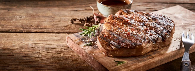 Rolgordijnen Gourmet grilled steak and condiments on timber © exclusive-design
