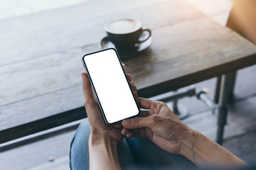 cell phone Mockup image blank white screen.woman hand holding texting using mobile on desk at coffee shop.background empty space for advertise text.people contact marketing business,technology