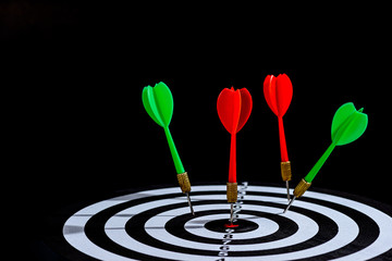 Fototapeta na wymiar Red and green dart arrow hitting target center is Dart board Isolated on black background