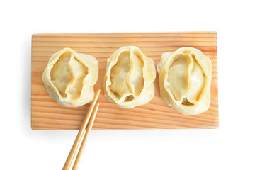 Board with oriental dumplings on white background
