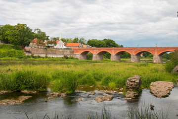 Fototapeta na wymiar the widest waterfall in Europe, Kuldiga, Latvia. With an old brick bridge across the Venta River