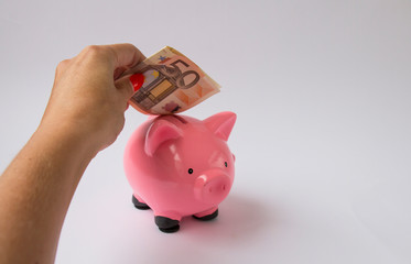 girl's hand in a piggy bank save 50 euros