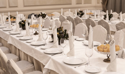 Festive table setting background. Serving a large festive restaurant table in anticipation of guests in a soft dim light.