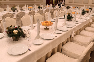 Festive table setting background. Serving a large festive restaurant table in anticipation of guests in a soft dim light.
