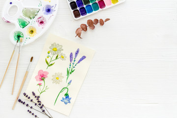 Watercolor painting. Picture with flowers, paints, palette on white background top-down copy space