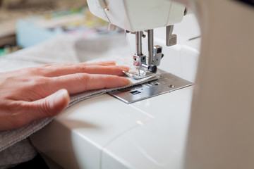 Seamstress hand guides seam on modern sewing machine