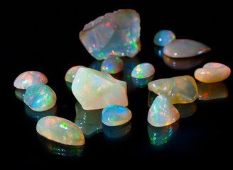 Composition of precious opal jewels. Cuts and rough material