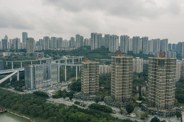 Obraz premium Aerial drone shot of crowded riverside mountain top residential building with flyover by Yangtze river