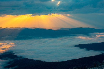 from the rocks we see the sunset and the fluffy clouds