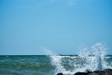 Image of the sea shore. In the background is a warship.