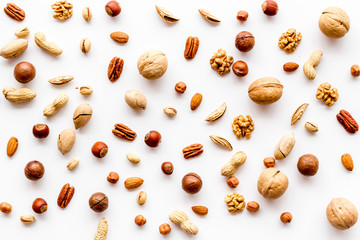 Nuts background - with almond, macadamia, walnut - on white table top-down