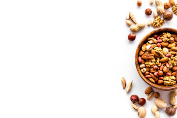 Mixed nuts in bowl on white background top-down frame copy space