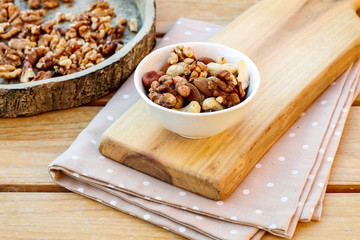 Bowl with mixed nuts. Wooden background.