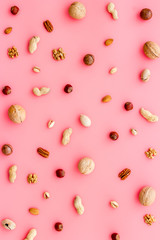 Nuts background - with almond, macadamia, walnut - on pink table top-down