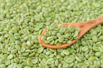 Spoon with green coffee beans, closeup