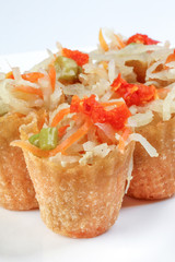 Pie Tee thin crispy Southeast Asian pastry tart shell kuih filled with spicy sweet mixture of thinly sliced vegetables and prawns on white background