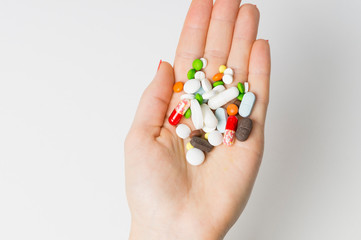 pills on a woman's hand top view on a white background