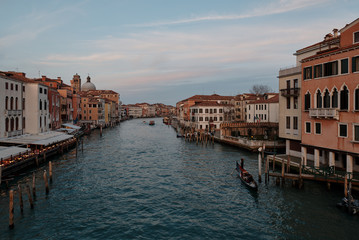 Fototapeta na wymiar Venice, Veneto/Italy - February 16 ,2020: View over the Grand Canal in Venice and a gondola crossing the grand canal during sunset 