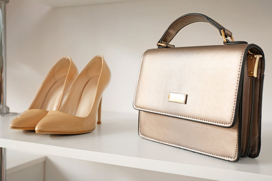 Stylish Female Shoes And Bag On Shelf In Wardrobe